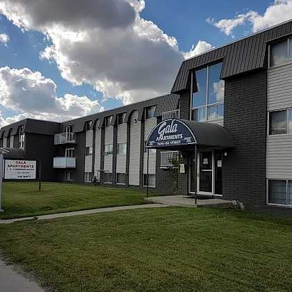 a building with a sign that says "gala apartments".