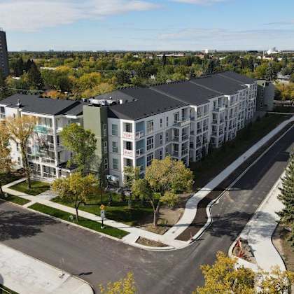 a road with a car driving down it and apartment buildings on the side.