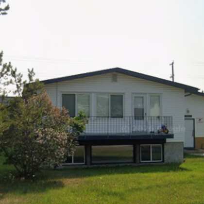 a house with a white exterior and a balcony.