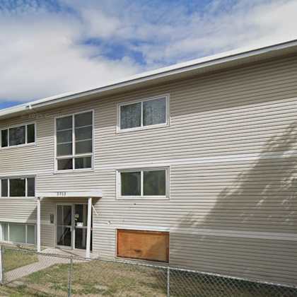 a grey building with a fence in front.