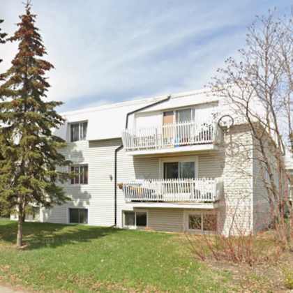 a white apartment building with a balcony on the second floor.