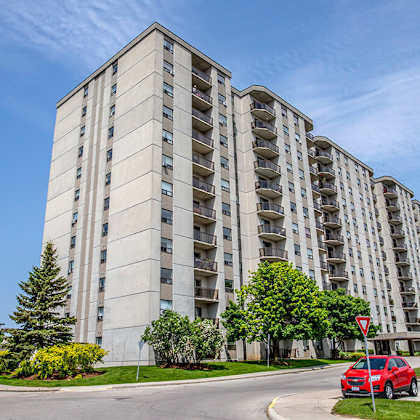 a picture of an apartment building with cars parked in front of it