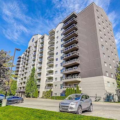 a large apartment building with cars parked in front of it