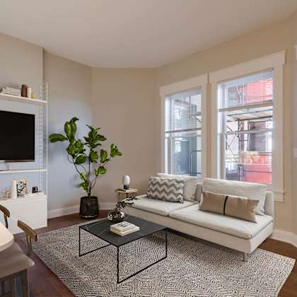 a living room with a white couch, a coffee table, and a flat screen tv.
