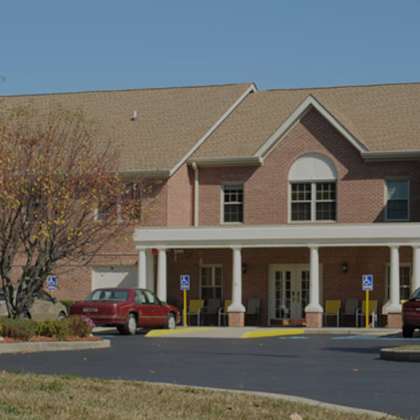 a building with a flag on top and cars parked in front.