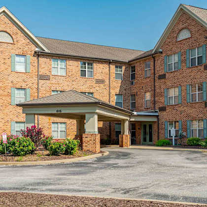 a large brick building with a driveway in front.