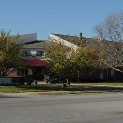 a street with cars and a building with a red awning.