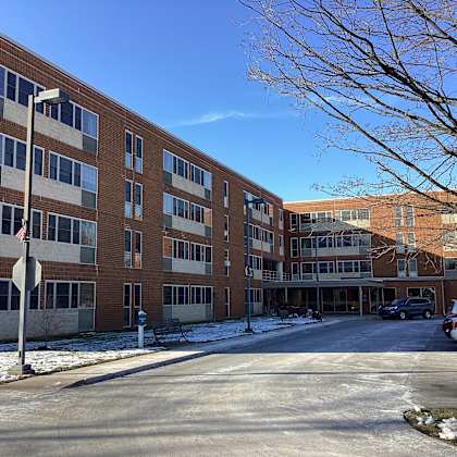 a large brick building with a parking lot in front.