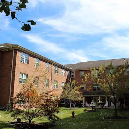 a large red brick building with a green lawn in front.
