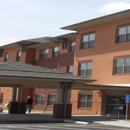a building with a brown brick facade and a covered walkway.