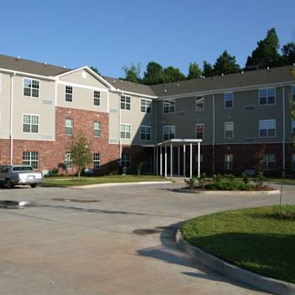 a parking lot in front of a multi-story apartment building.