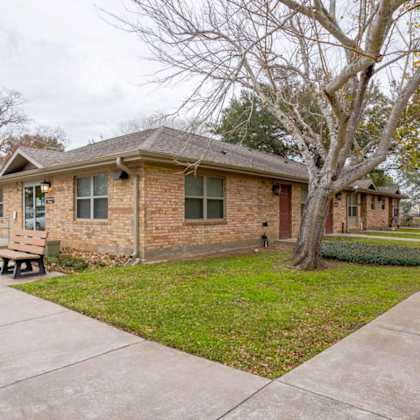 a brick house with a tree in front of it.