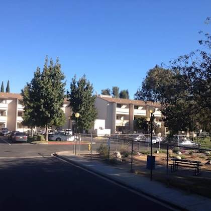 a parking lot in front of a building with cars parked.