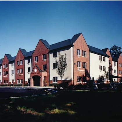 a large red brick building with a tree in front of it.
