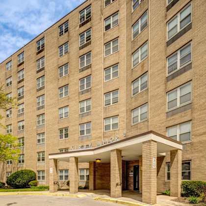 the building in the image is a large brick apartment complex with a flag flying in front.