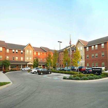 a parking lot in front of a large brick building with a sign that says "the commons".