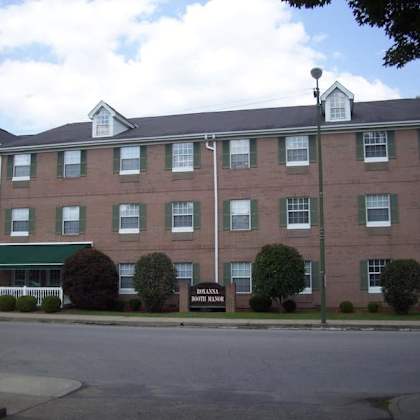 a large red brick building with a green awning and a sign that says "downtown inn".
