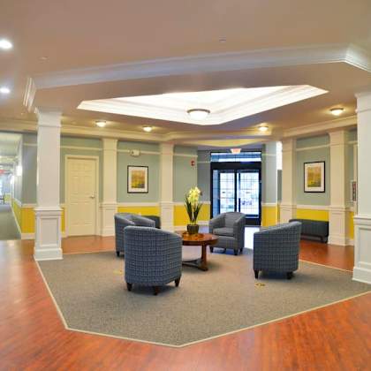 a hallway with a carpeted area and chairs.