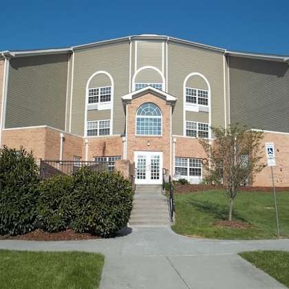 a large building with a grey roof and a white door in the center.