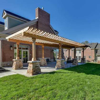 a house with a covered patio and a stone pillar.