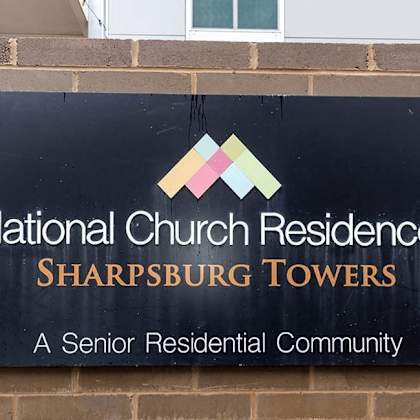 a sign for national church residences sharpsburg towers, a senior residential community.