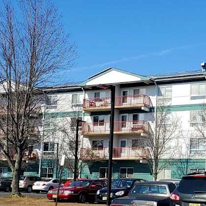 apartment building with cars parked in front.