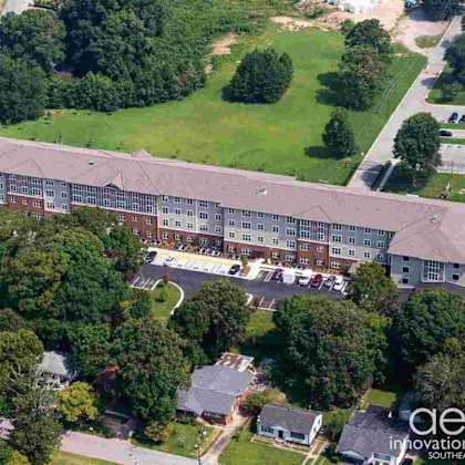 an aerial view of a building with a parking lot in front of it.