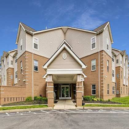a large, multi-story building with a brick facade and a covered entrance.