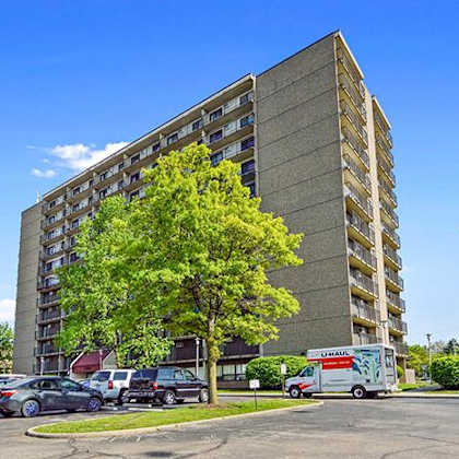 a tall building with a parking lot in front of it.