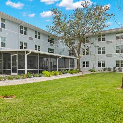 a sunny day at a grassy courtyard in front of a multi-story building.