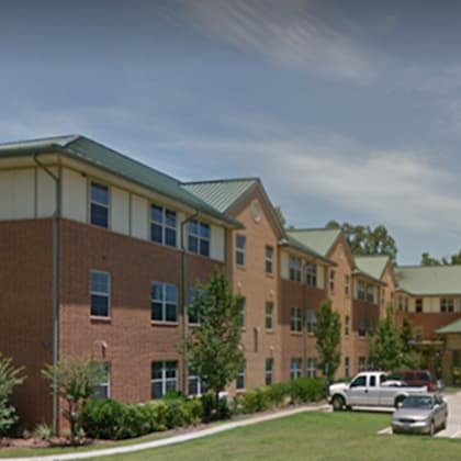 a large building with a parking lot in front.