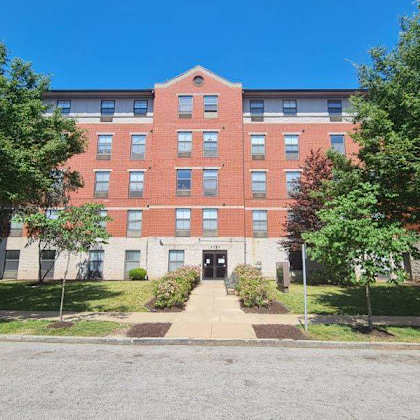 a red brick building with a green lawn in front.