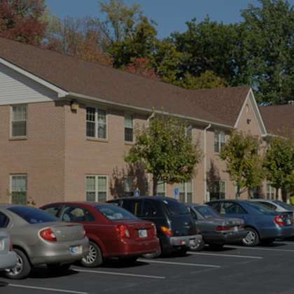 a parking lot in front of a building with cars parked.
