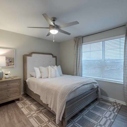 a bedroom with a bed, nightstand, and window.