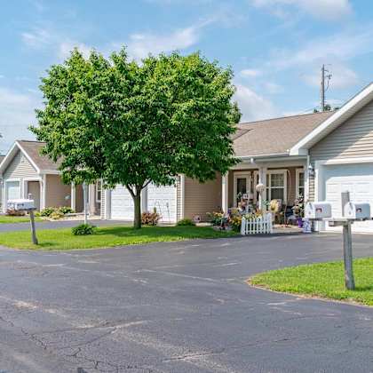 a residential area with houses and a tree in front of one of them.
