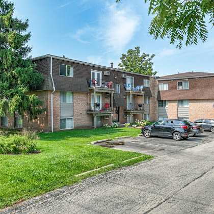 a row of houses with cars parked in front.