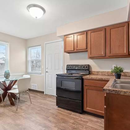 a kitchen with wooden cabinets and a table with chairs