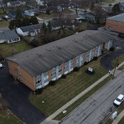 a parking lot is in front of a building with a long row of cars parked.