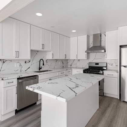 a kitchen with white cabinets and white marble countertops at seaview terrace apartment homes, san clemente, 92672