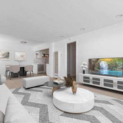 a modern living room with a white couch and a large television.