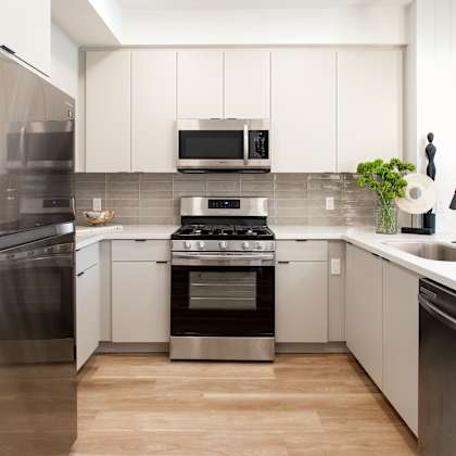 a modern kitchen with stainless steel appliances and white cabinets. at the reserve la mirada, la mirada
