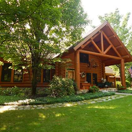 a large log cabin with a large lawn in front of it