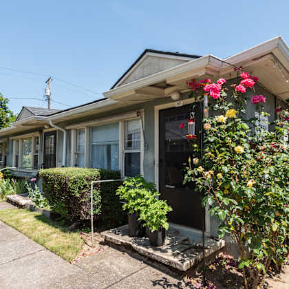 a house with a grey roof and a flower box on the front.