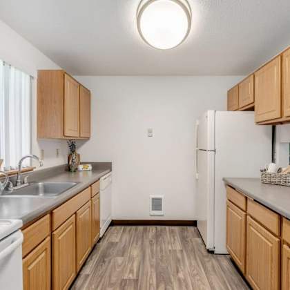 a kitchen with wooden cabinets and a white refrigerator.at alder creek apartments, vancouver, wa 98682