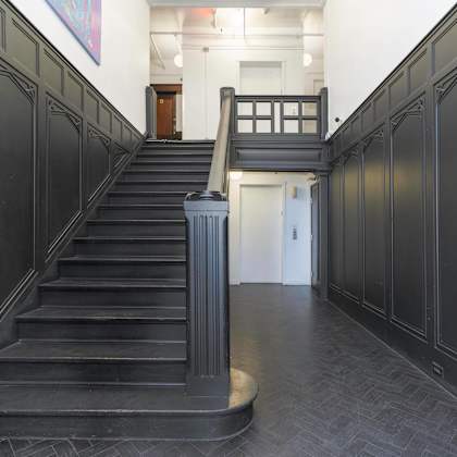 the lobby of a building with a staircase and black doors at clay & tiffany, portland, 97201