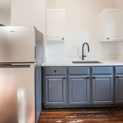 a kitchen with a stainless steel refrigerator and a grey cabinet at midtown apartments, portland, or, 97209