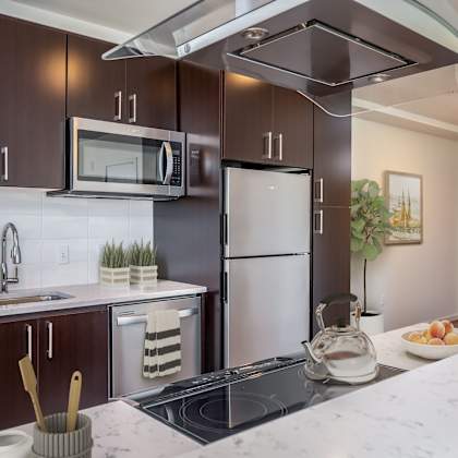 a modern kitchen with dark brown cabinets and a white marble countertop.