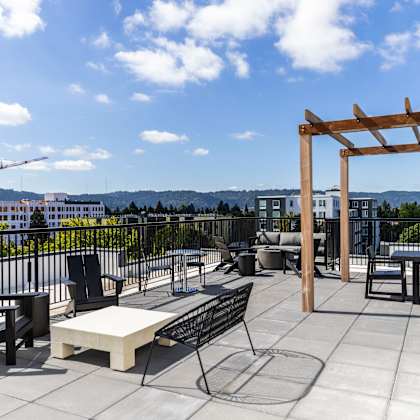a rooftop patio with tables and chairs and a view of the city at shift, portland, or
