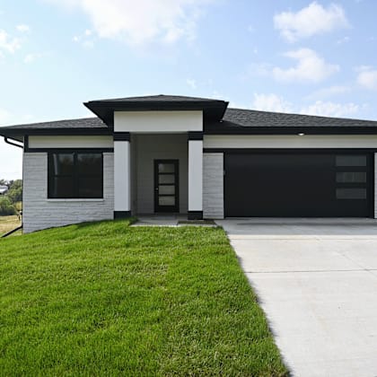 a modern house with a black roof and a white exterior.