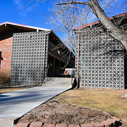 a building with a brick facade and a large tree in front.
